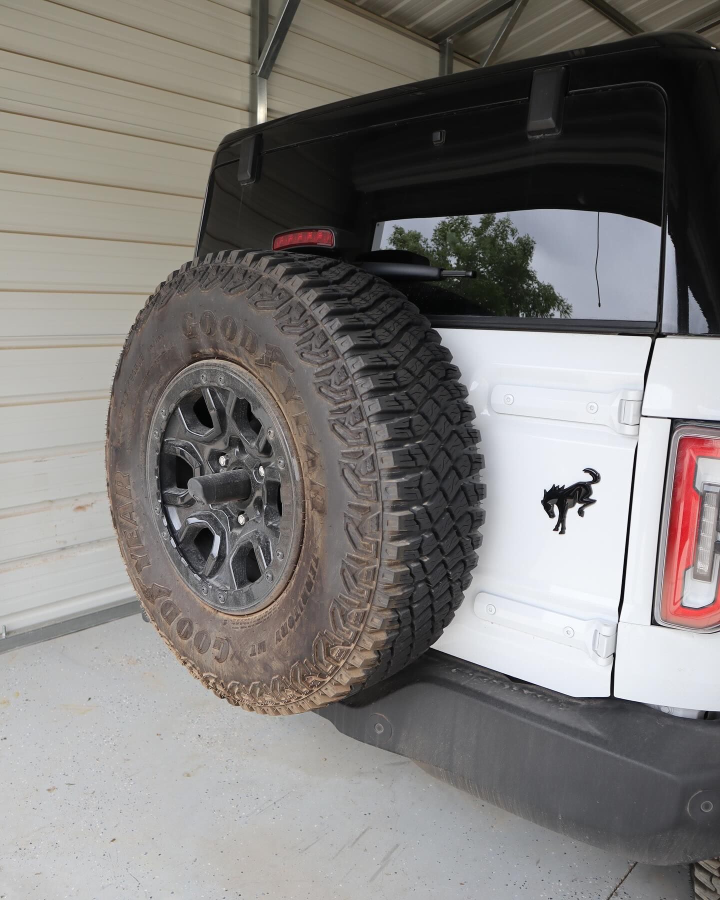 White SUV with a spare tire mounted on the back. A black Bronco logo is visible.