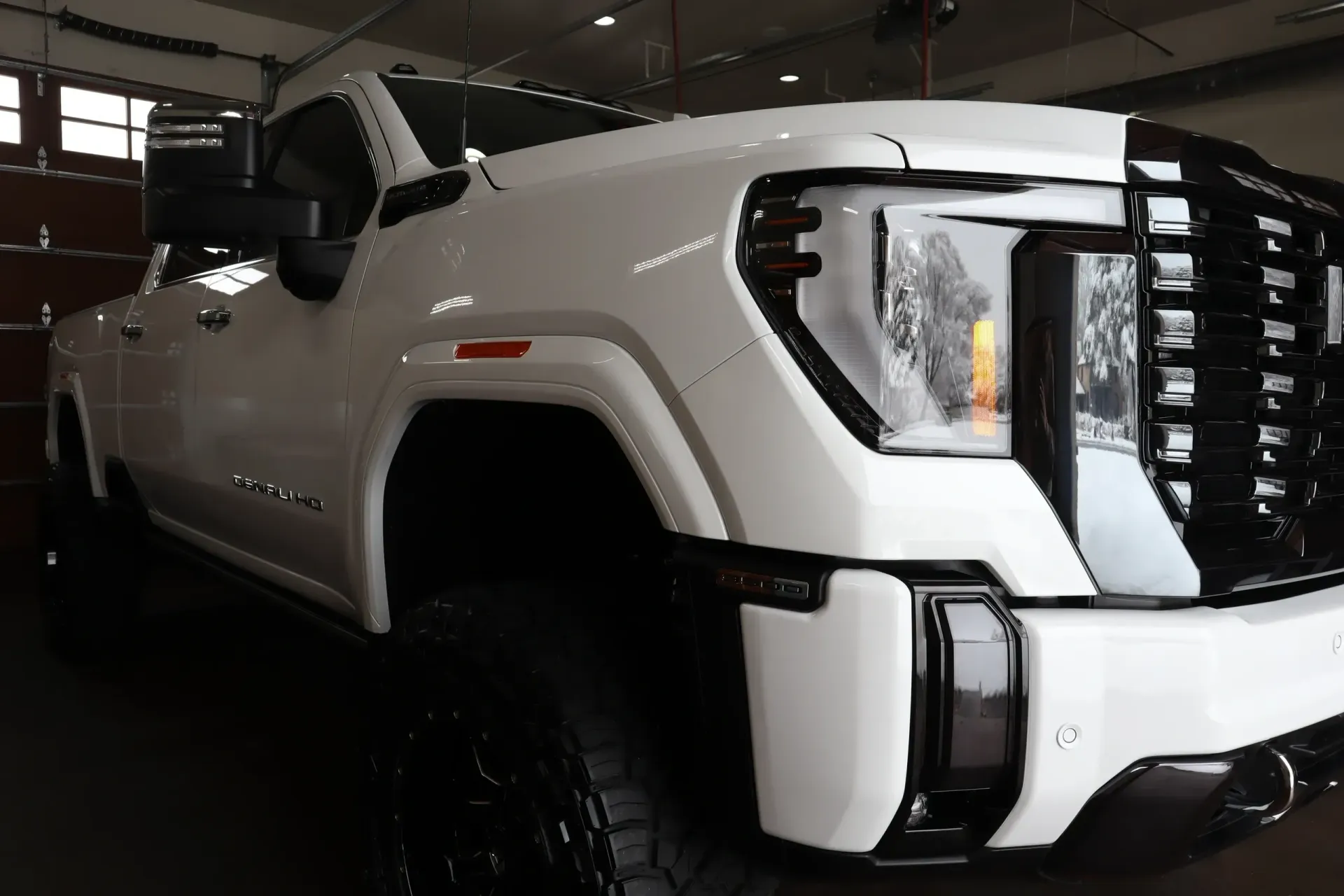 White GMC truck with black accents, parked indoors.