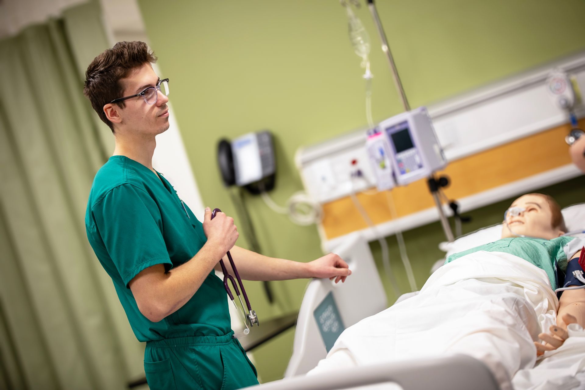 A nurse is standing next to a patient in a hospital bed.