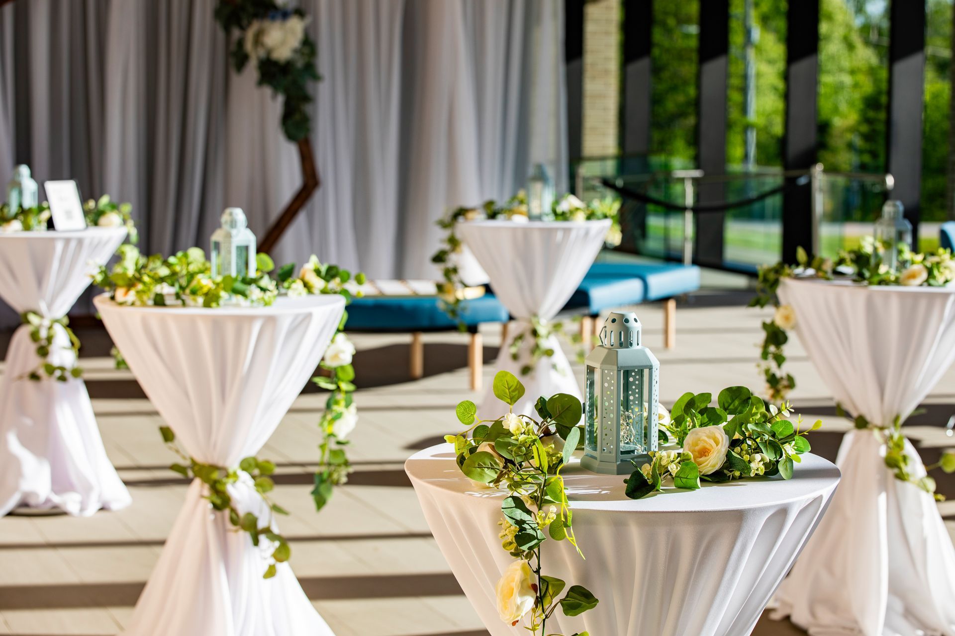 A living room with a couch , chairs , tables and a large window.