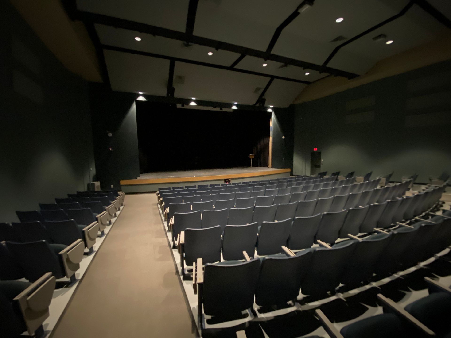 An empty auditorium with rows of seats and a stage