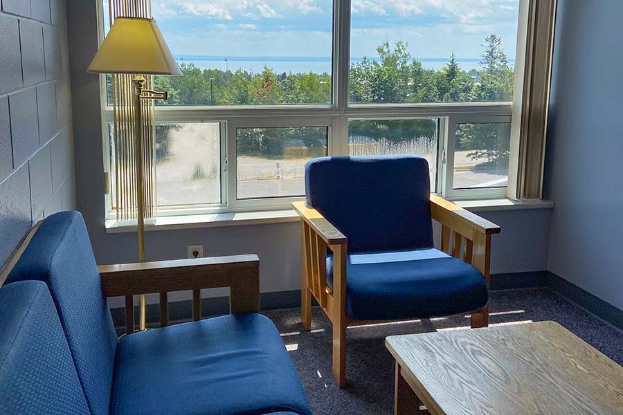 A living room with a couch , chair , table and window.