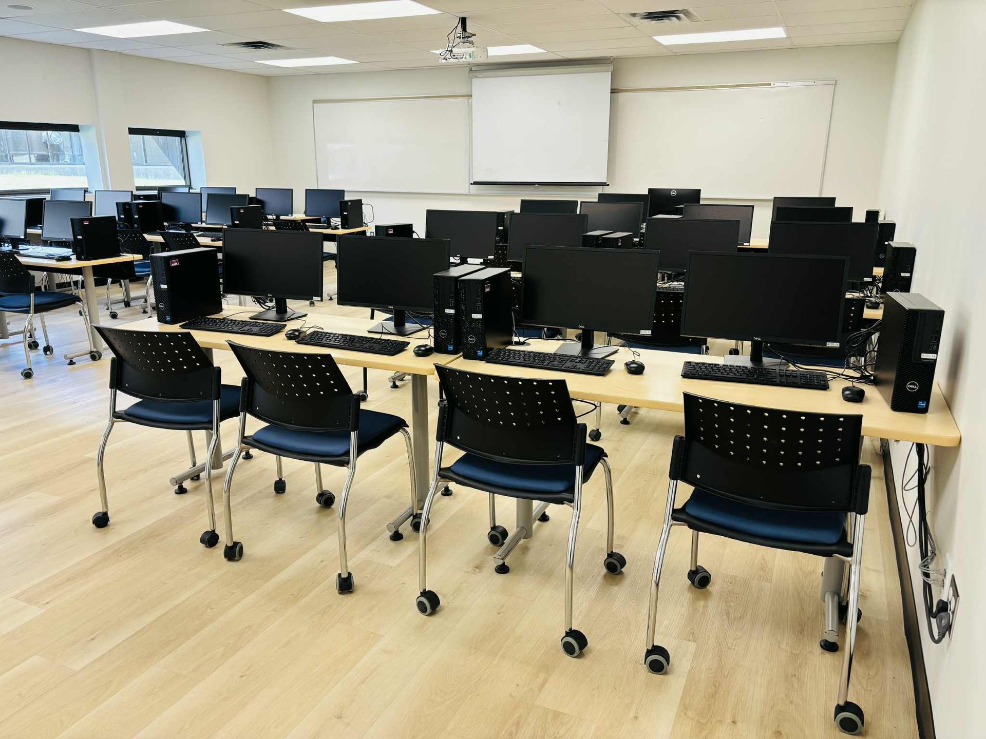 Modern interior: wood ceiling, linear lights, large windows, seating area, stairwell.