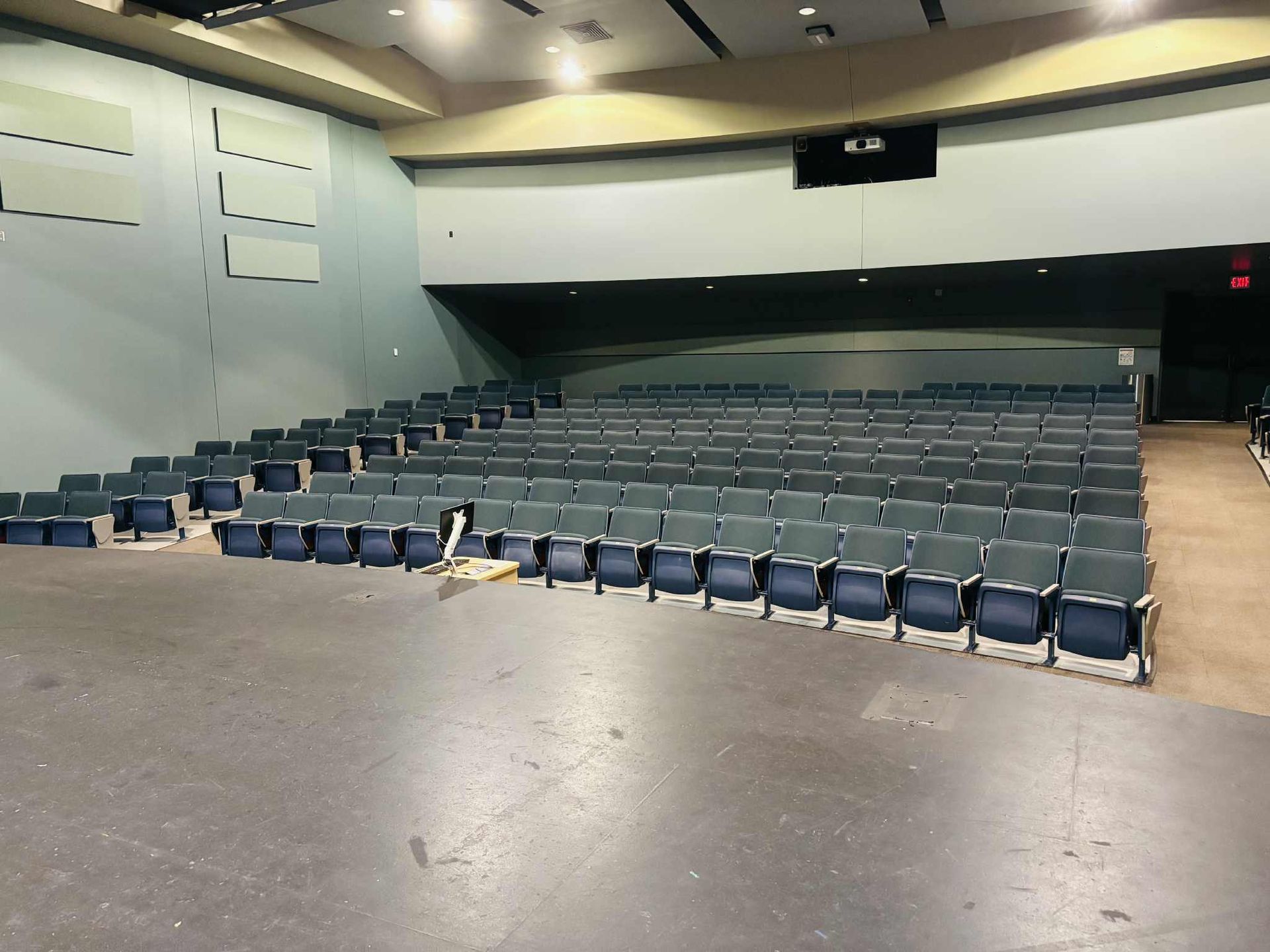 A modern cafeteria with tables, chairs, and booths; a curved wall with wood paneling and a neutral floor.