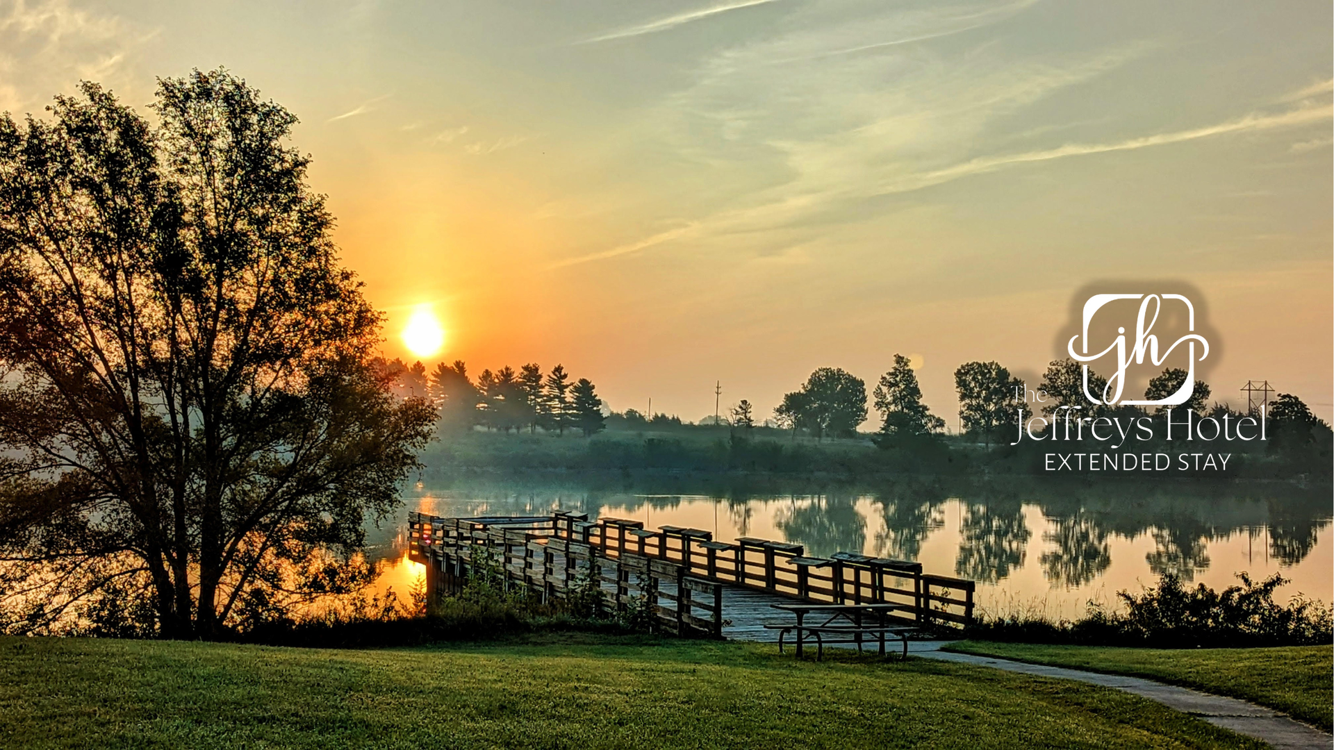 Sunrise over a lake with a wooden pier, trees, and