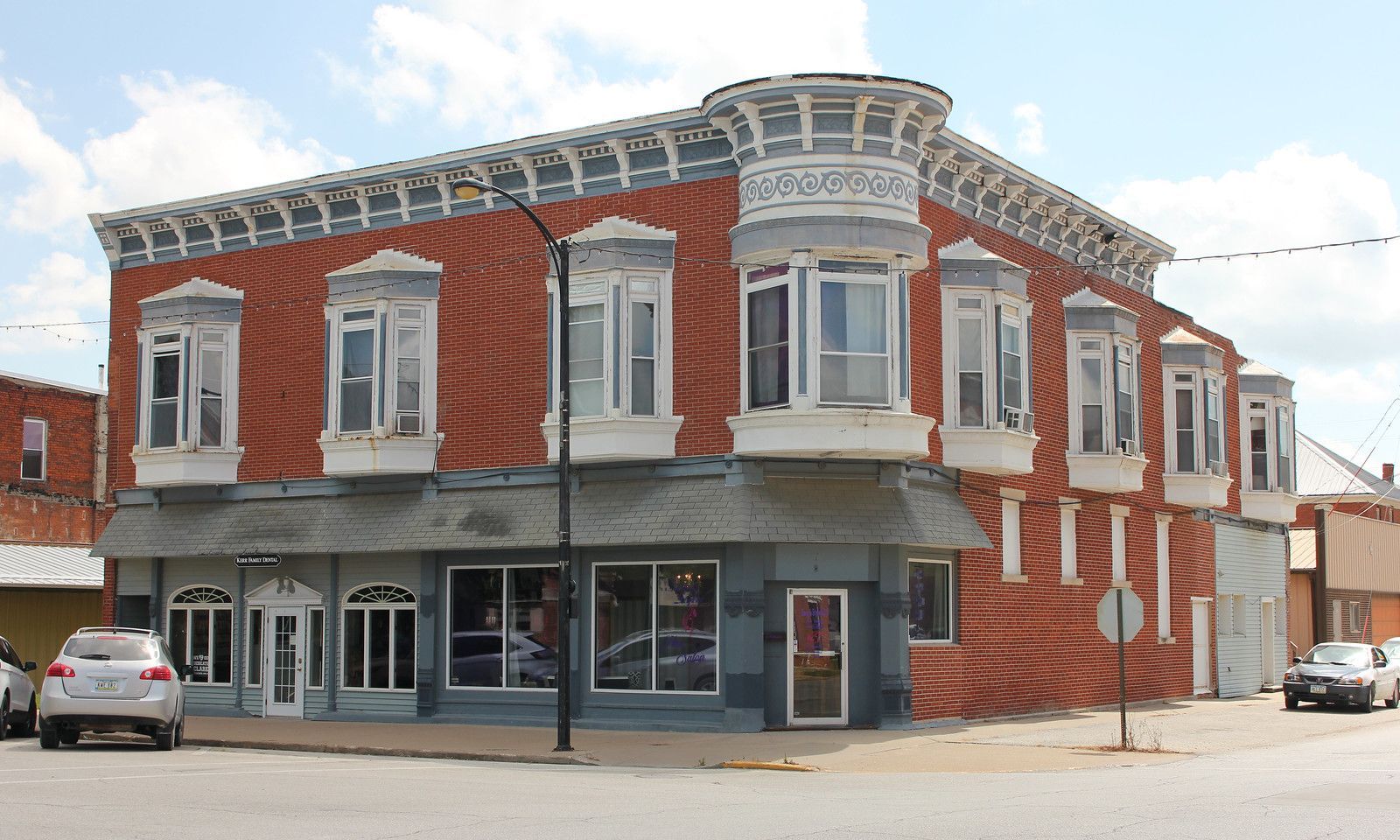 Historic red brick building with bay windows in downtown Osceola, Iowa, featuring classic architecture and corner storefront