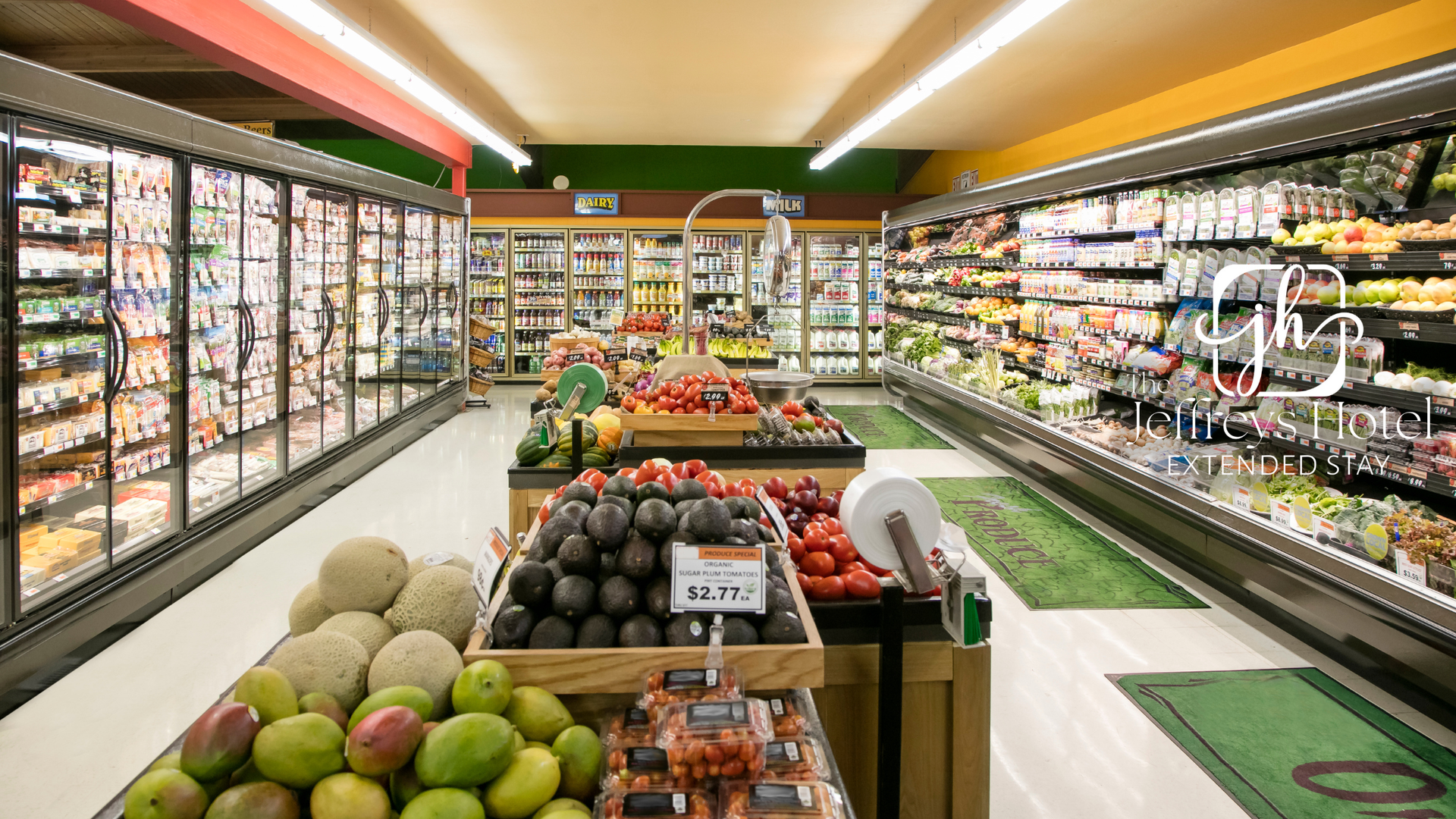grocery store with produce display in foreground and refrigerated cases lining the walls