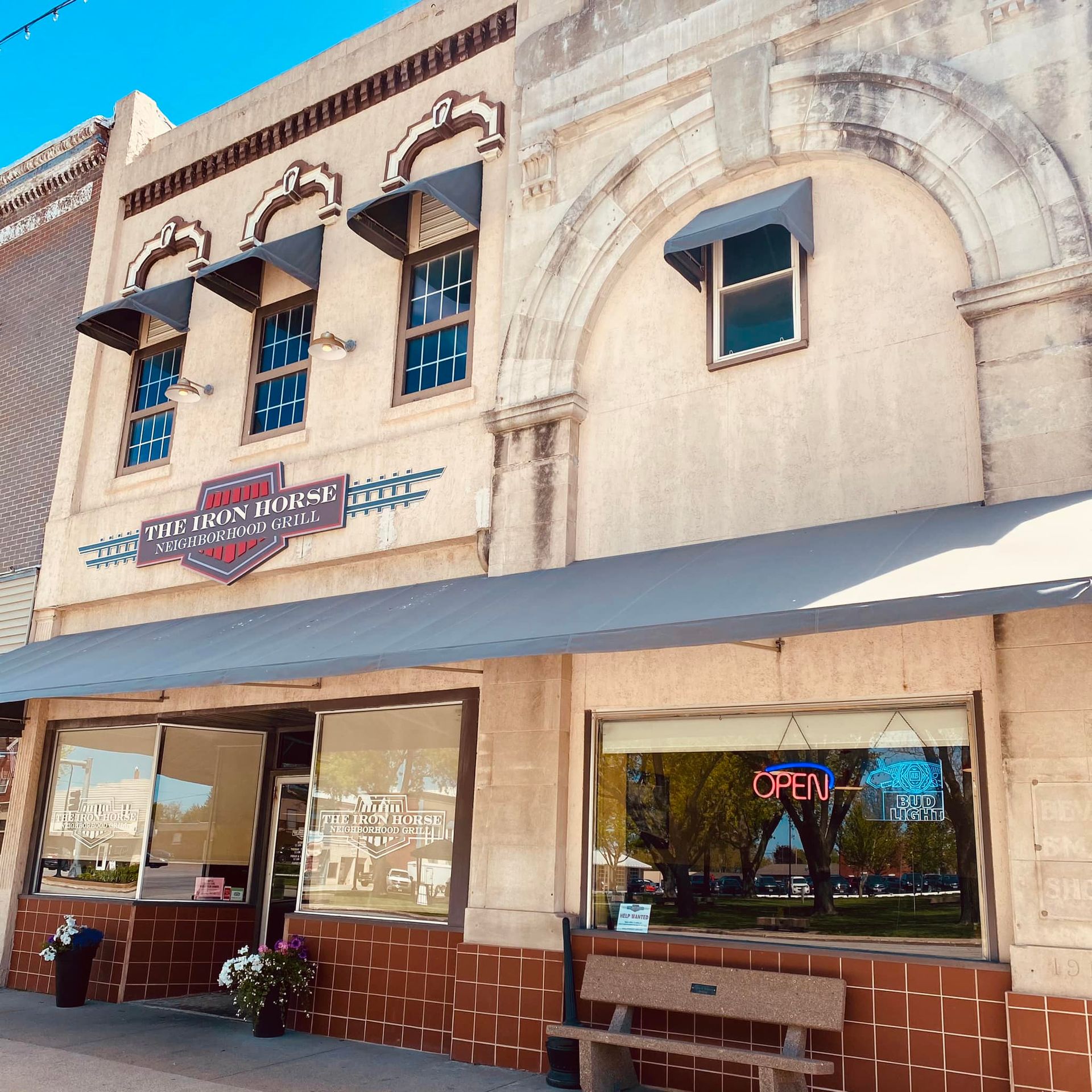 Iron Horse Neighborhood Grill storefront in historic downtown Osceola, Iowa, featuring arched windows and outdoor seating