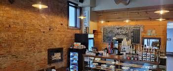 Interior of Mayberry's coffee shop with brick walls, wood paneling, and a counter.