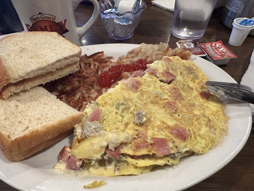 Breakfast plate with omelet, hash browns, toast, and ketchup.