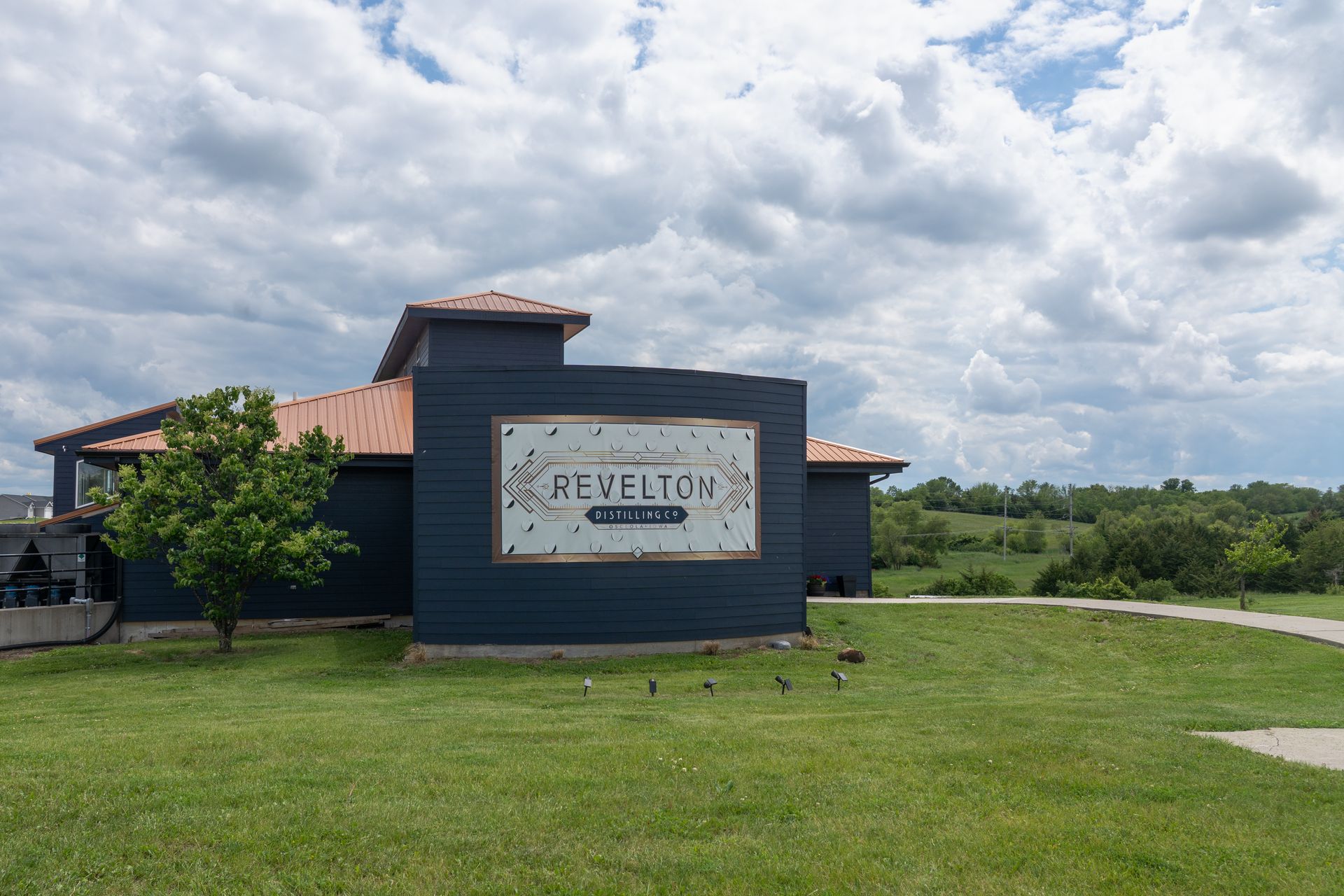 Revelton distillery building in Osceola, IA with sign on blue exterior.