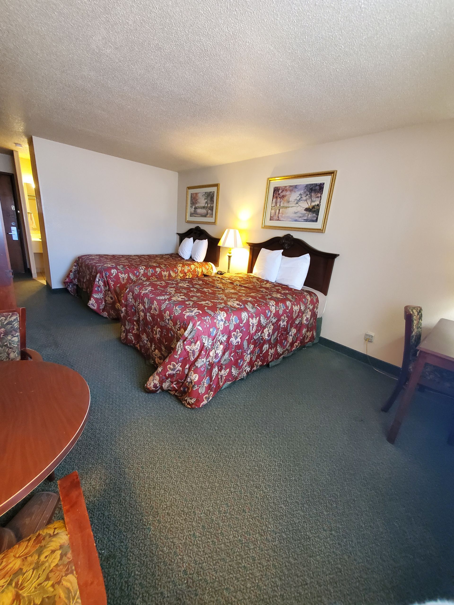 Well-lit double bed room with large windows at The Jeffreys Hotel, ideal for affordable long-term lodging in southern Iowa