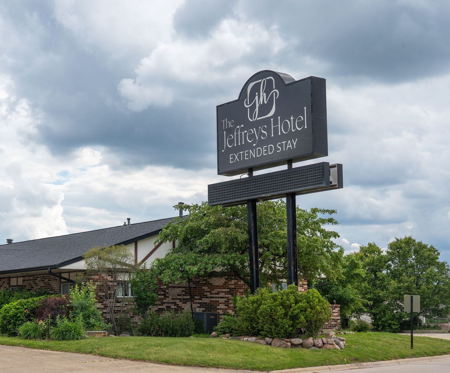 Exterior of The Jeffreys Hotel Extended Stay in Osceola, Iowa, featuring hotel signage and parking