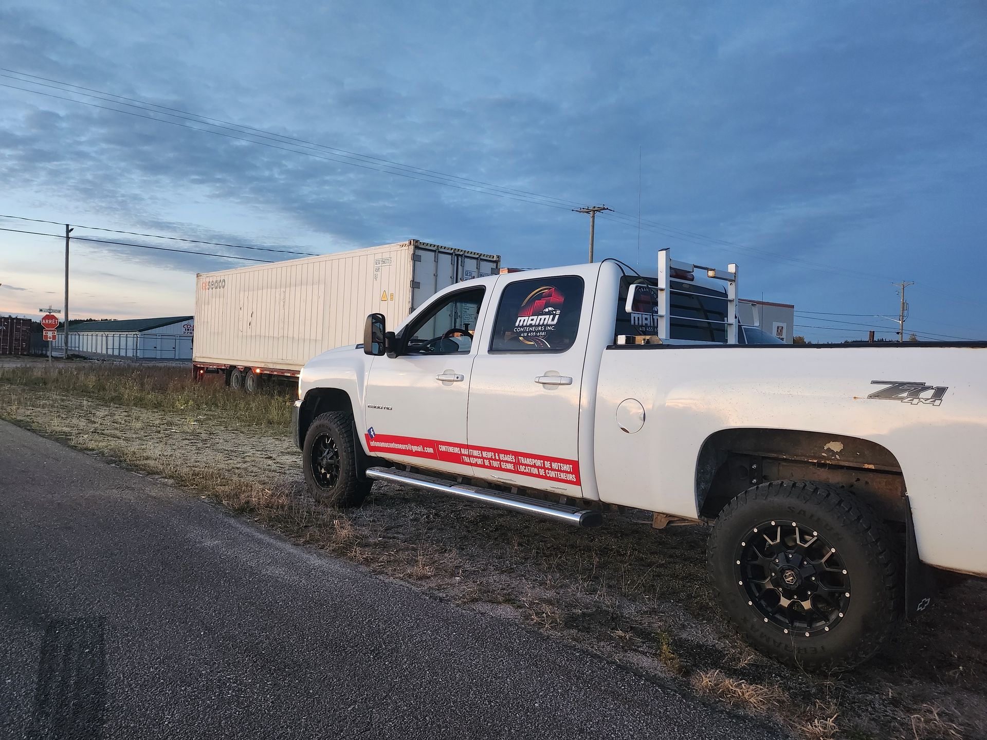 Un camion blanc est garé sur le bord de la route.