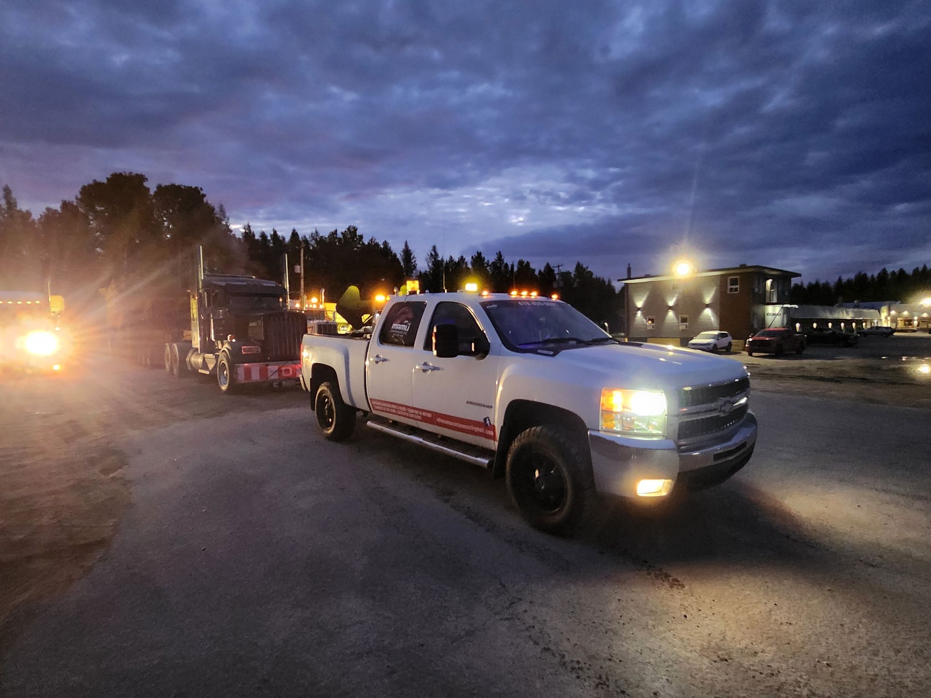 Un camion blanc est garé sur un parking la nuit