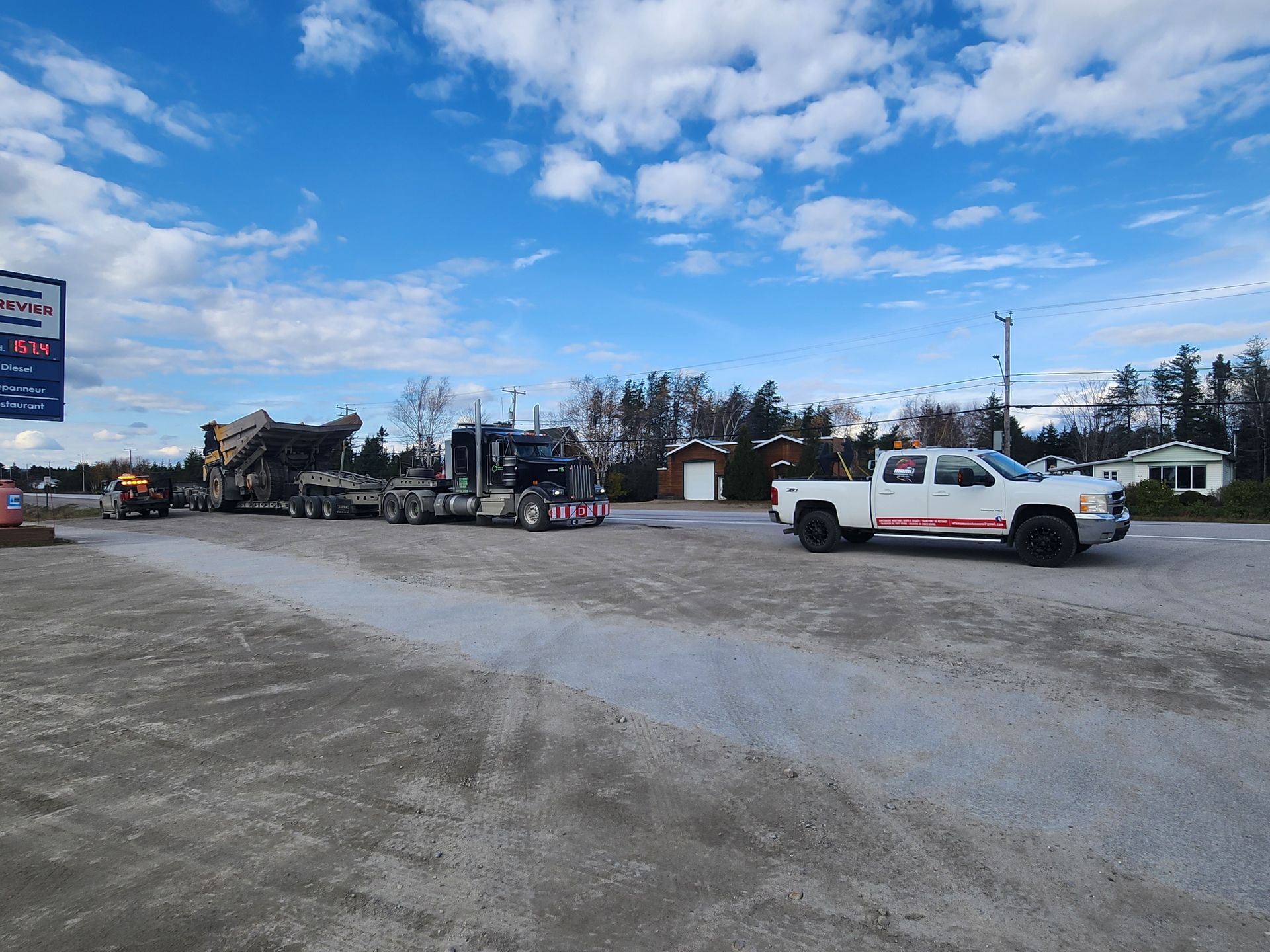Un camion blanc roule sur une route à côté d'un gros camion.