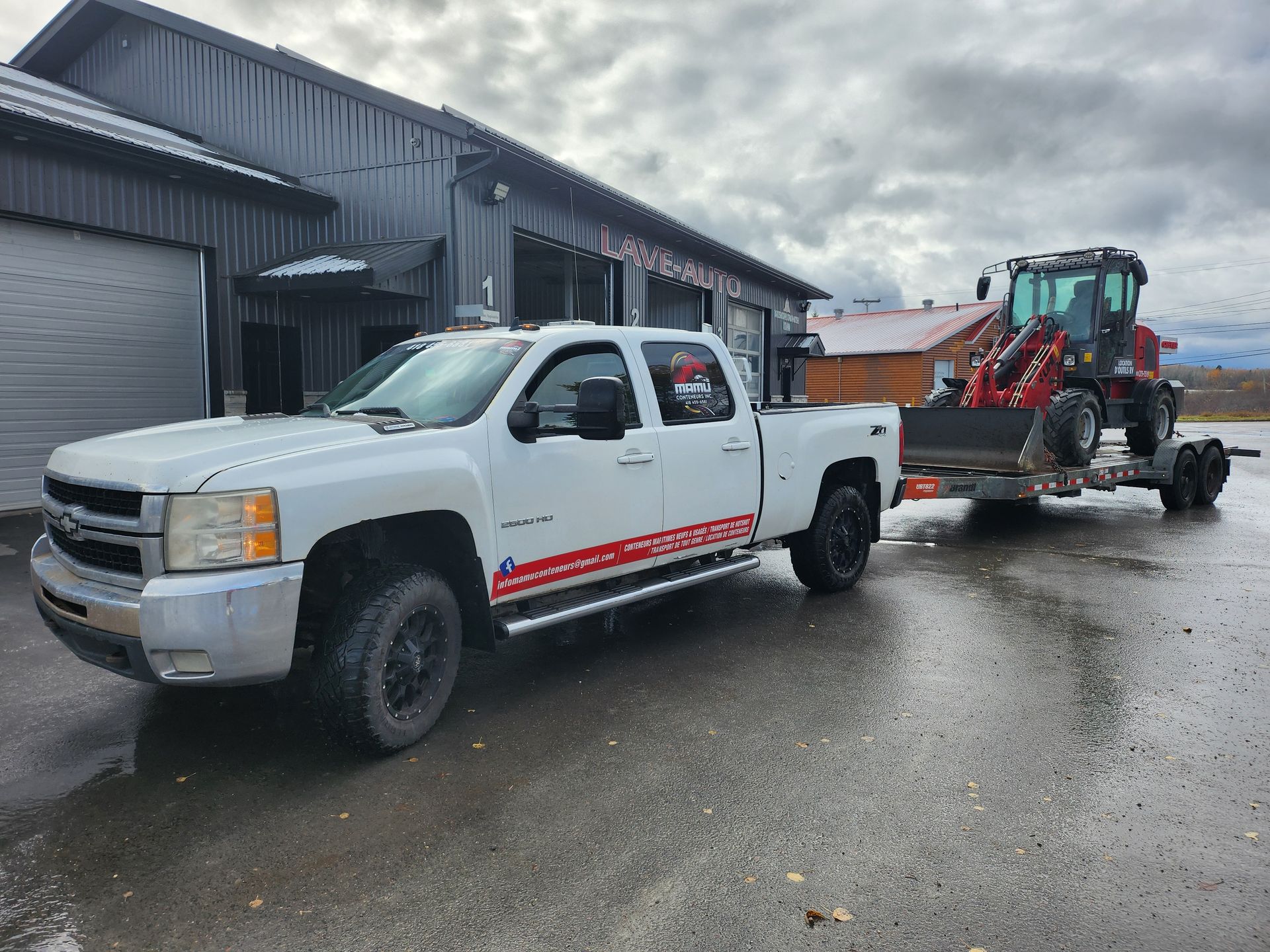 Un camion blanc tracte un tracteur sur une remorque.