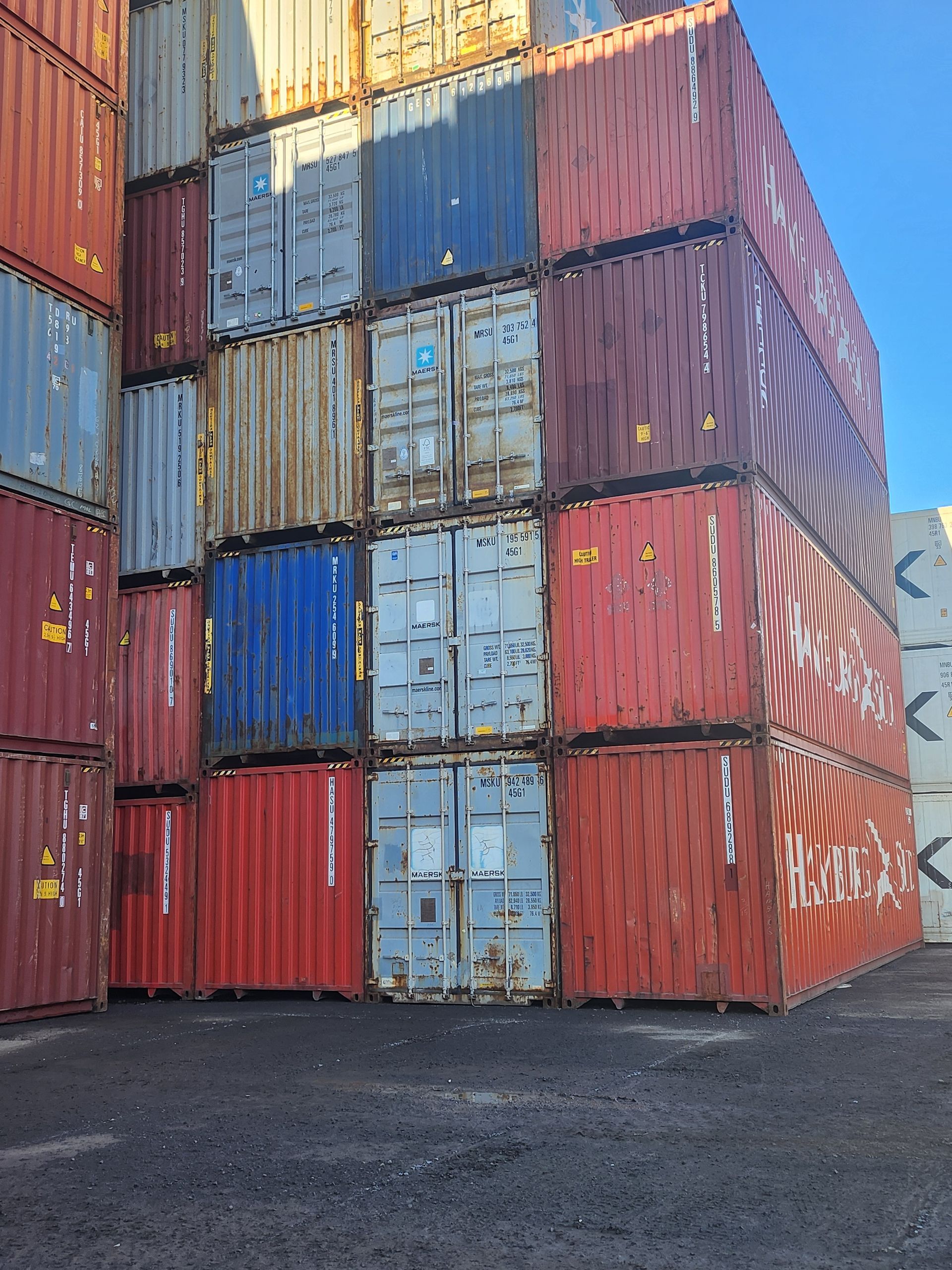 Un tas de conteneurs d'expédition sont empilés les uns sur les autres