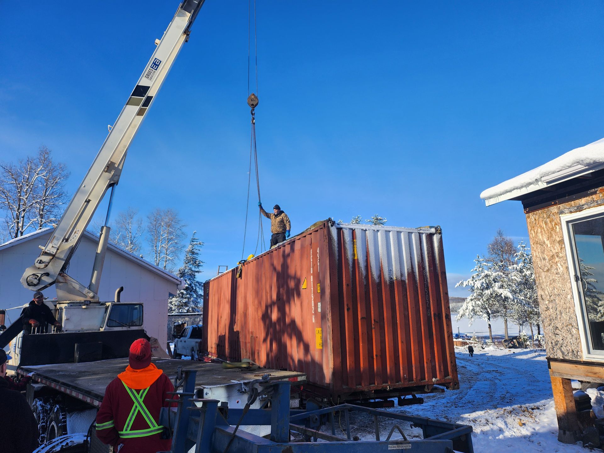 Une grue soulève un conteneur d'expédition dans la neige