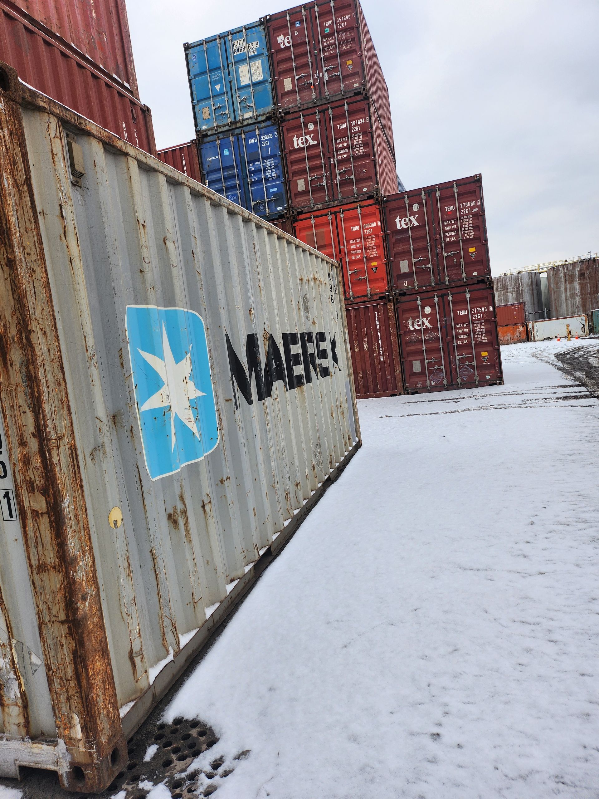 Les conteneurs d'expédition Maersk sont empilés les uns sur les autres dans la neige