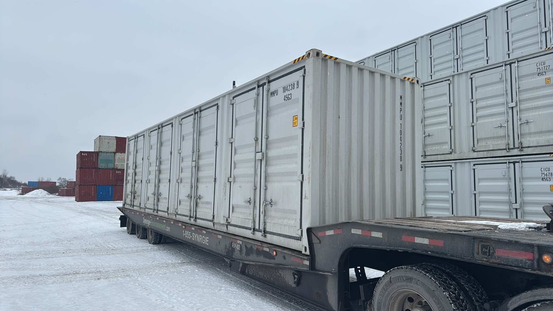 Un camion transporte un wagon rempli de conteneurs d'expédition.