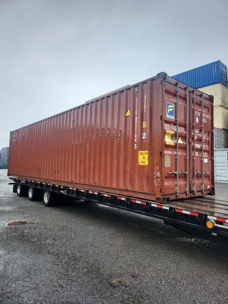 Un conteneur d'expédition rouge est posé sur une remorque.