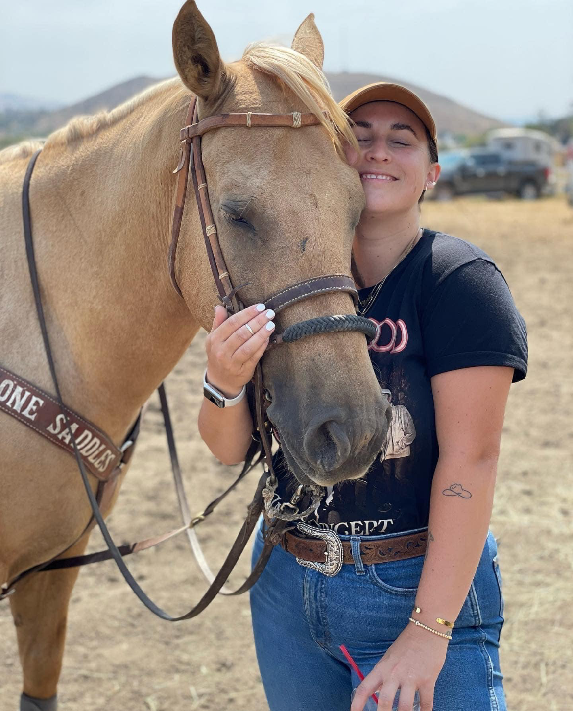 A woman is standing next to a brown horse.