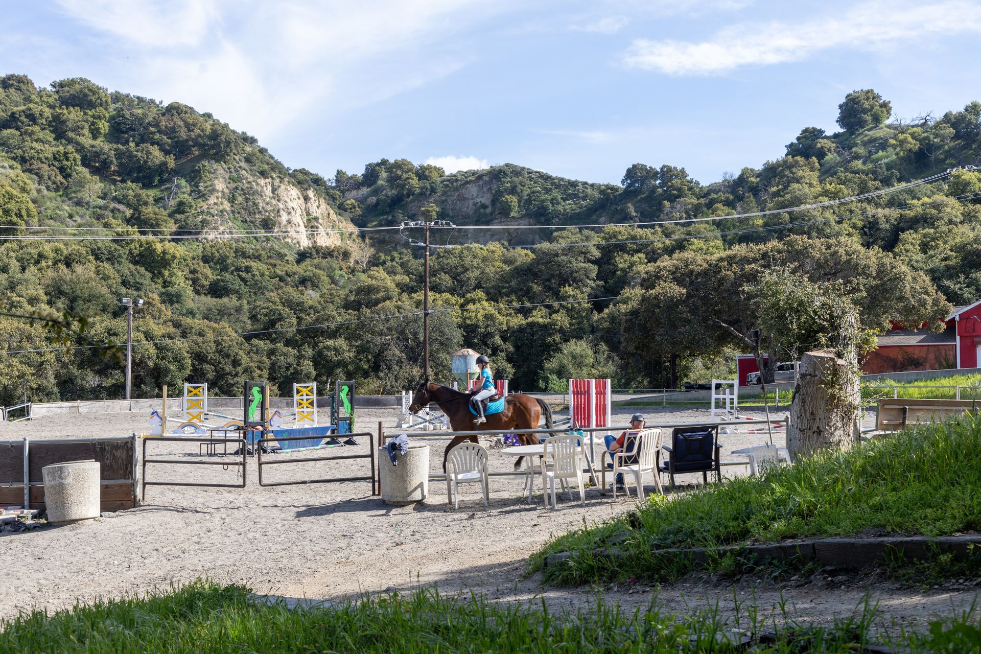 A person is riding a horse in a fenced in area.