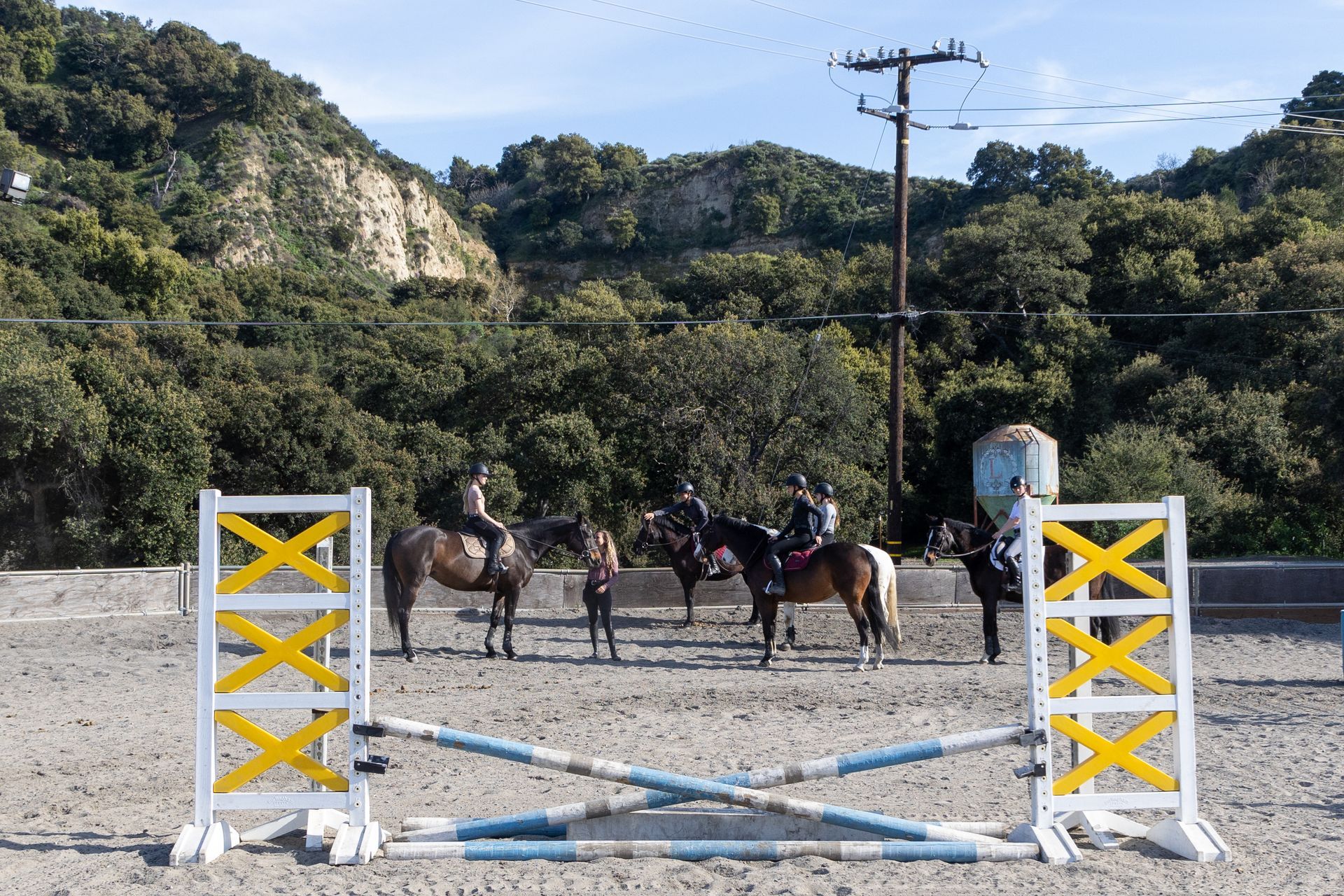 A group of people are riding horses in a dirt field.