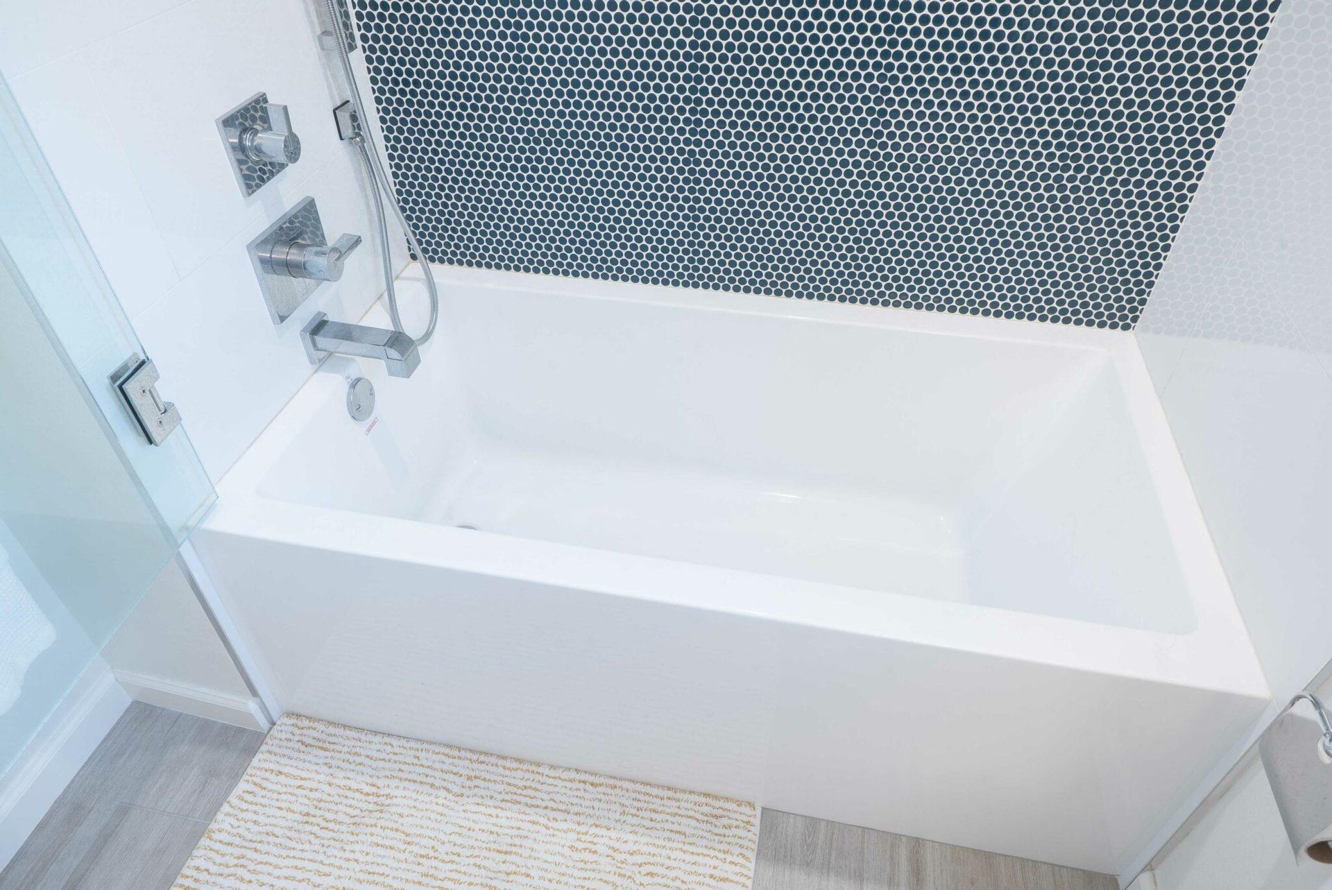 a white bathtub in a bathroom with a shower head .