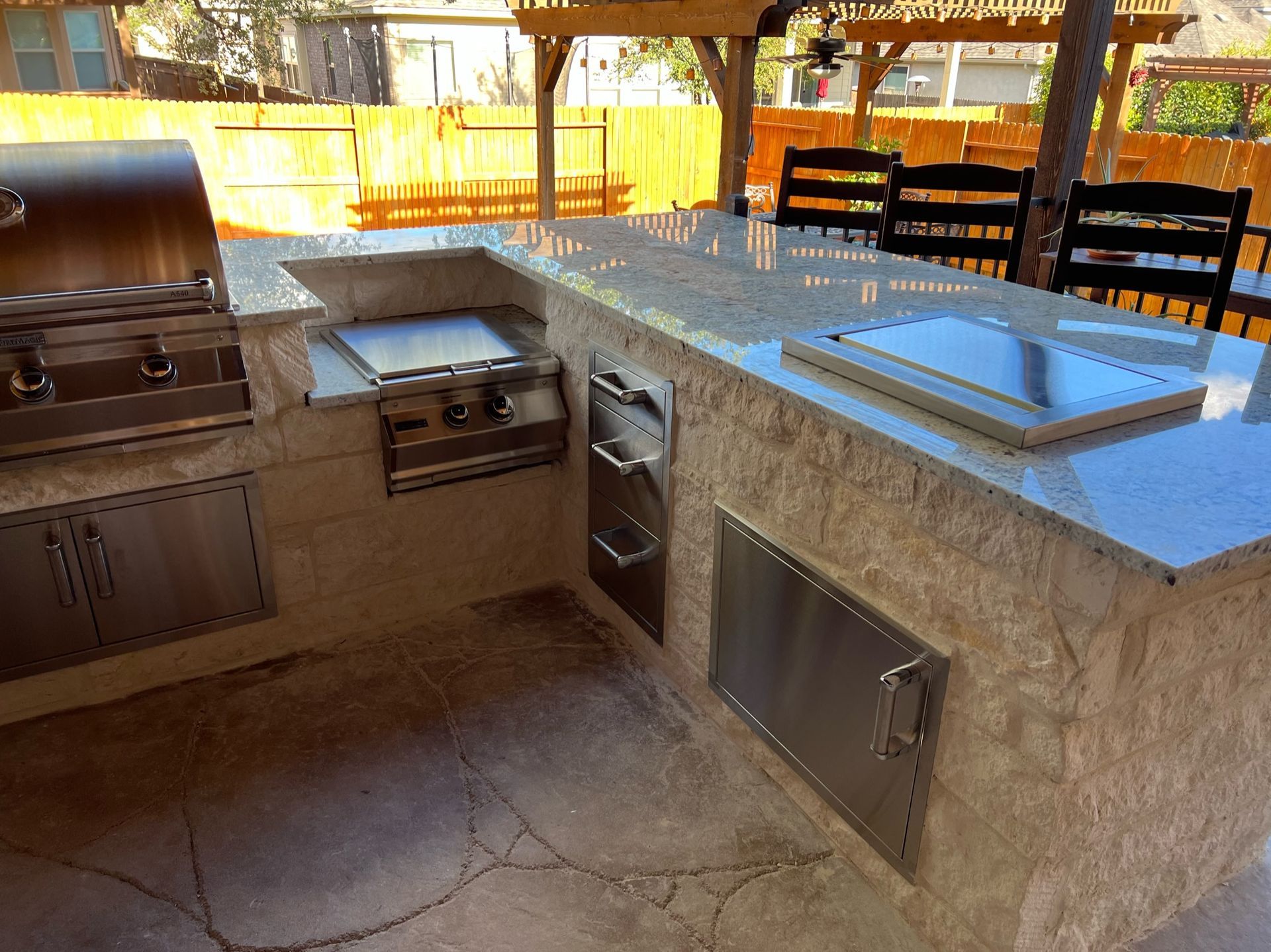 an outdoor kitchen with a grill and a sink