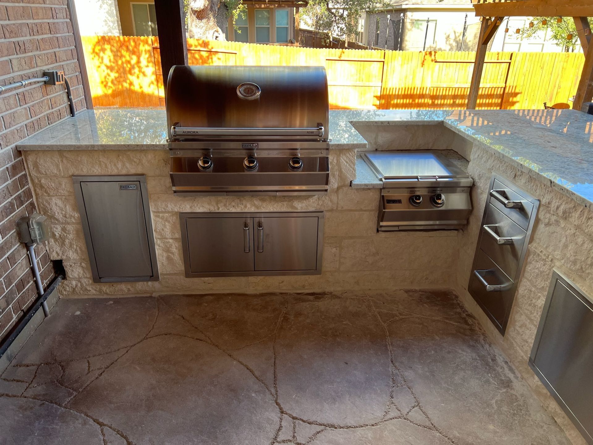 an outdoor kitchen with a grill and a sink