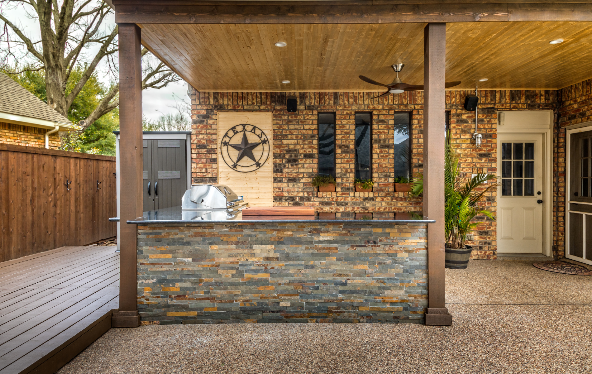 a patio with a grill and a texas star on the wall .