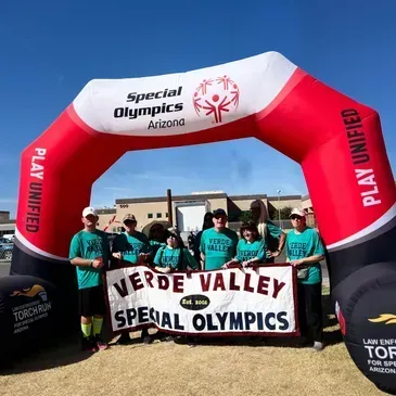 A group of people holding a sign that says verde valley special olympics
