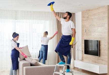 A group of people are cleaning a living room.