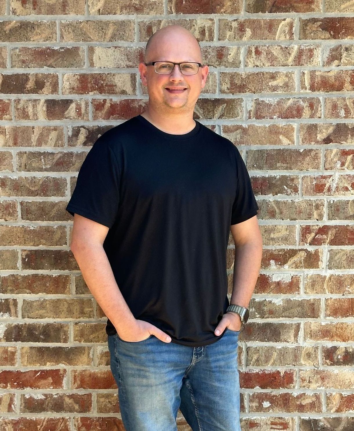 A dump truck is parked in a field with trees in the background.