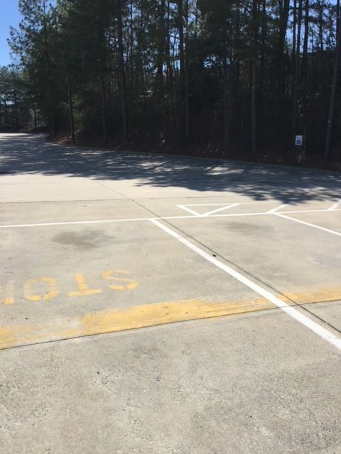 Concrete parking area with white lines and a yellow 