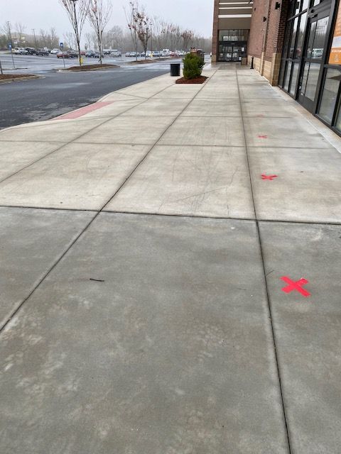 Sidewalk in front of a store with red 