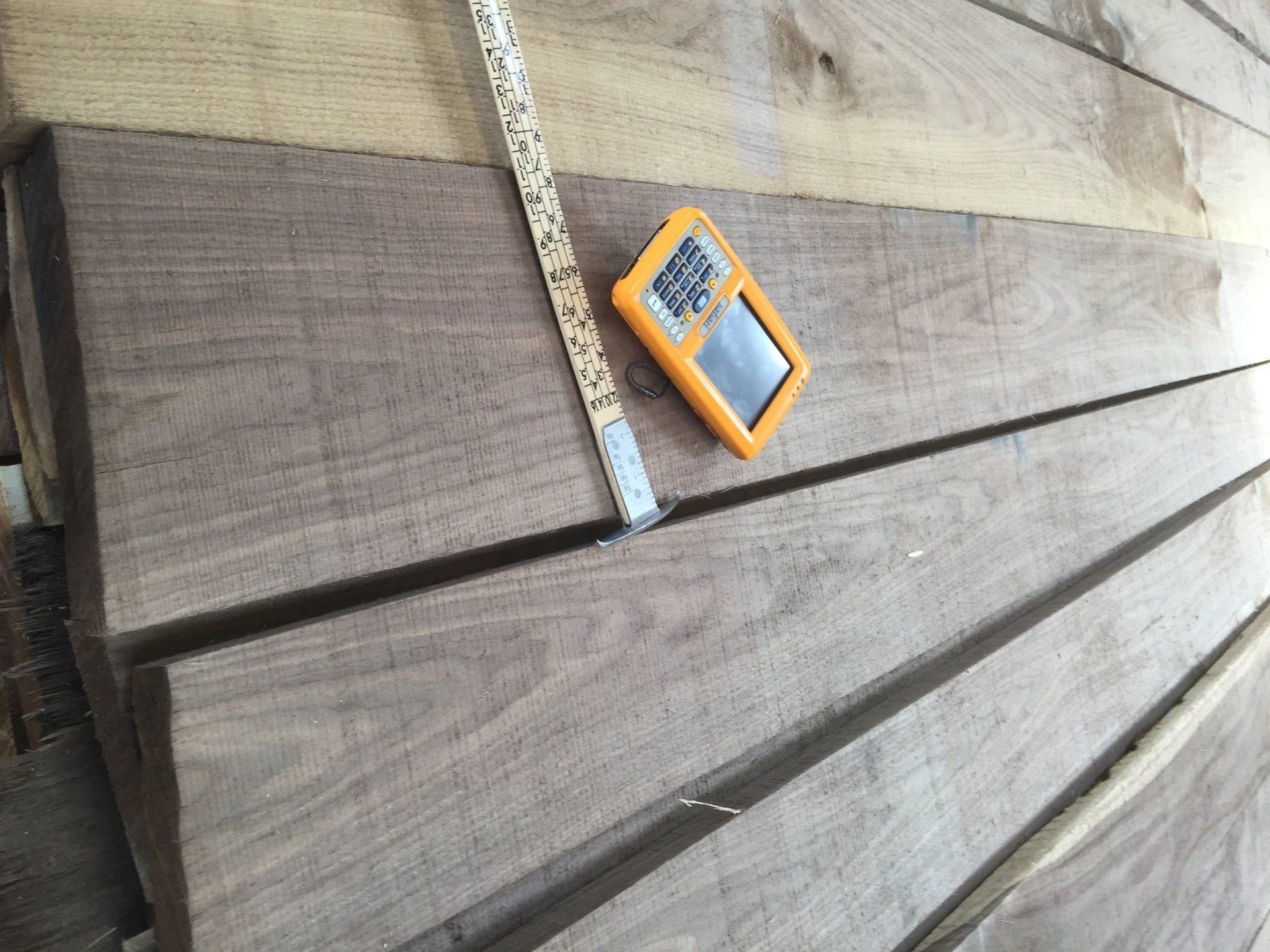 A measuring tape is laying on top of a piece of wood.