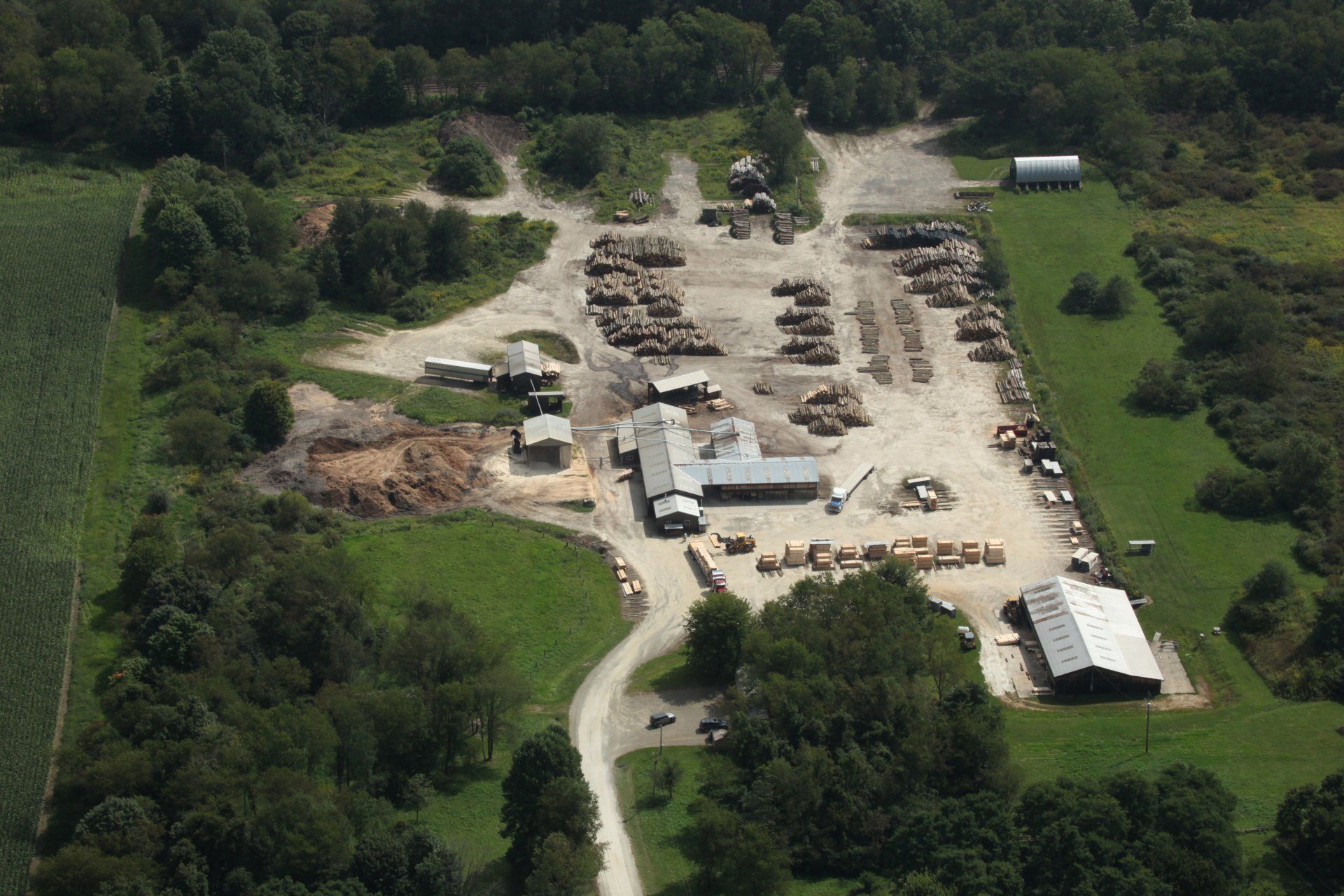 An aerial view of a farm with lots of trees and buildings