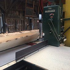 A large piece of wood is being cut by a machine.