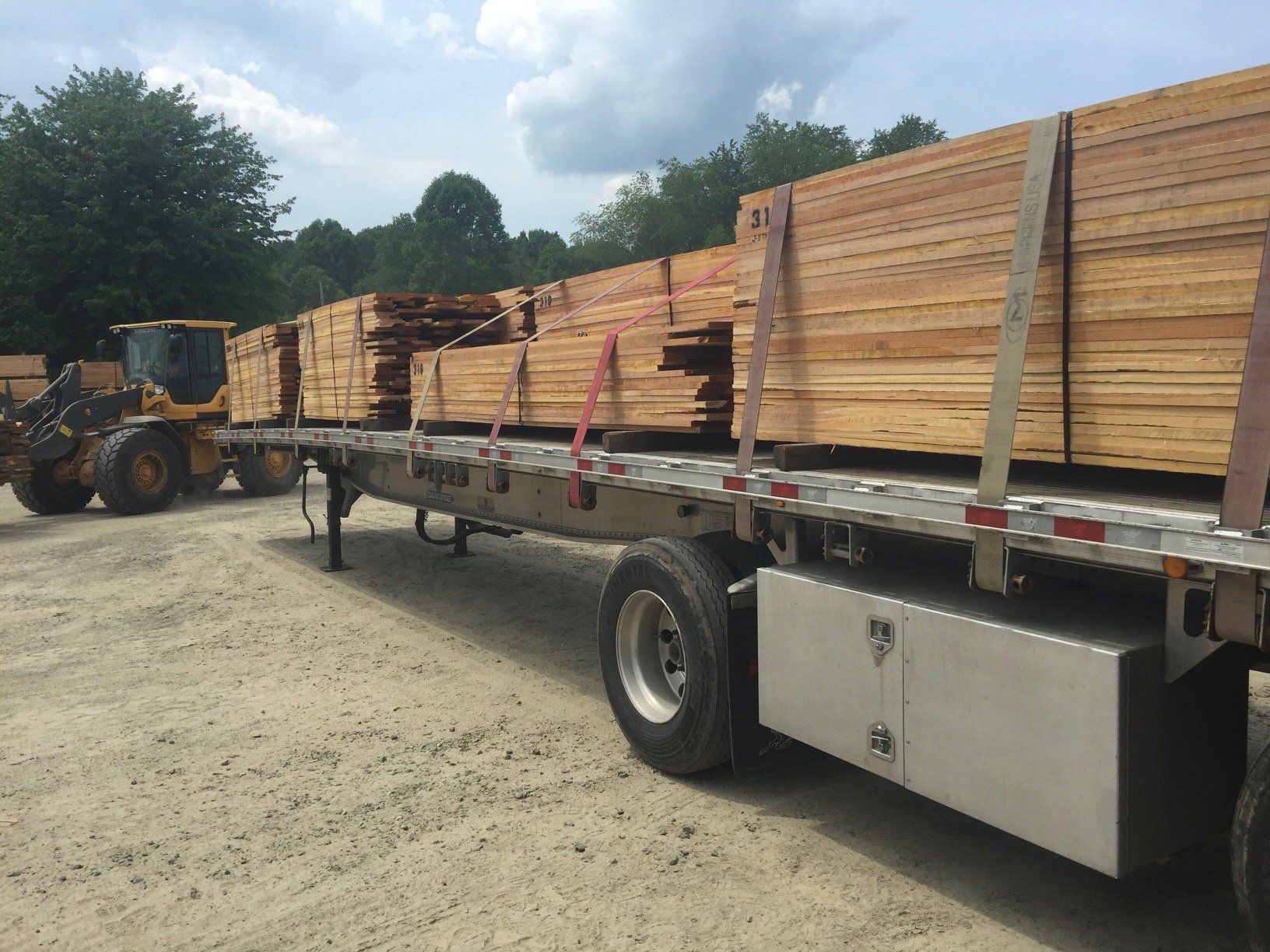 A semi truck is carrying a load of wood.