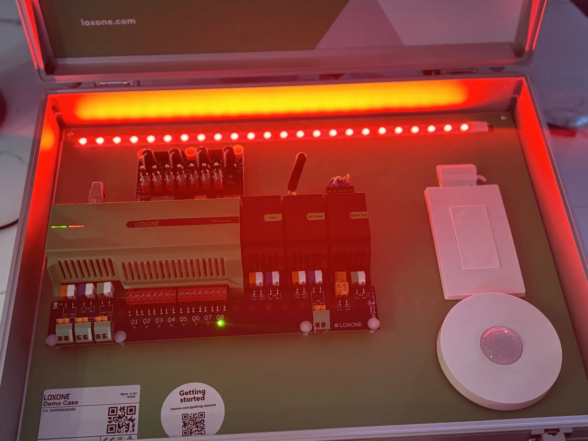 A portable technician case featuring an electronic circuit board with lit components and a white sensor disk.