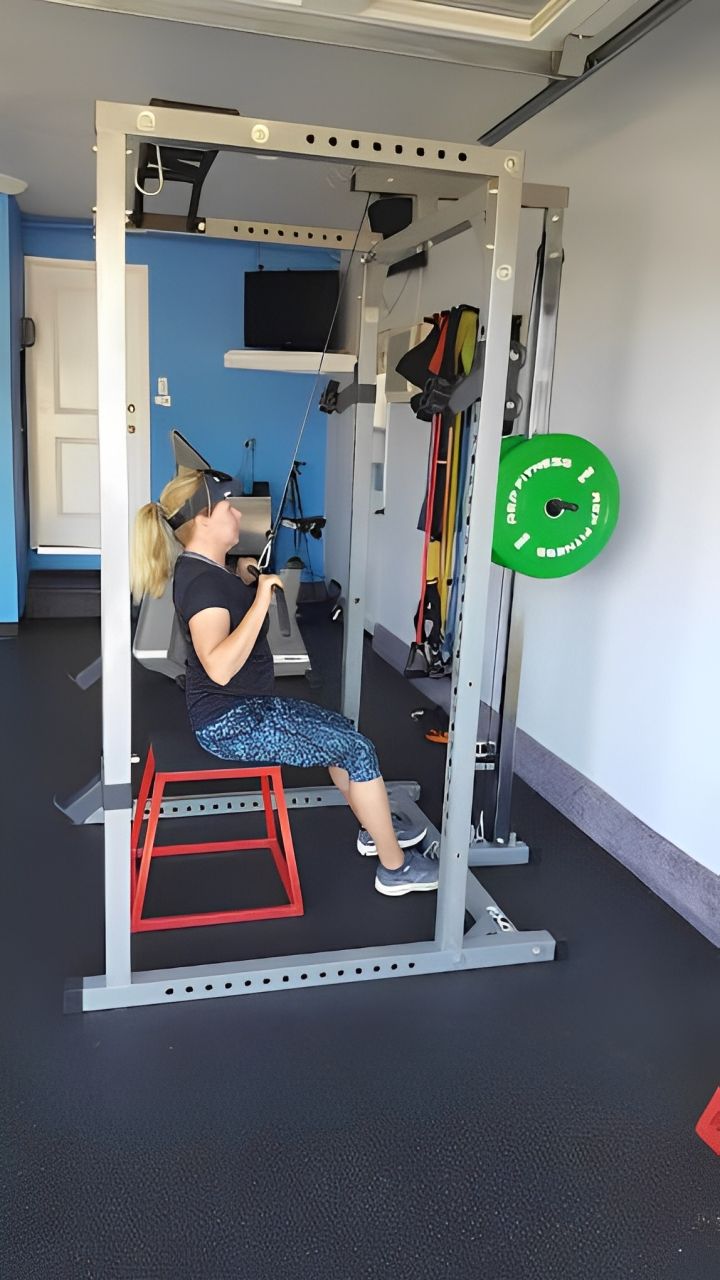 A man is sitting on a stool in a gym.