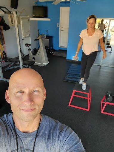 A man and a woman are doing exercises in a gym.