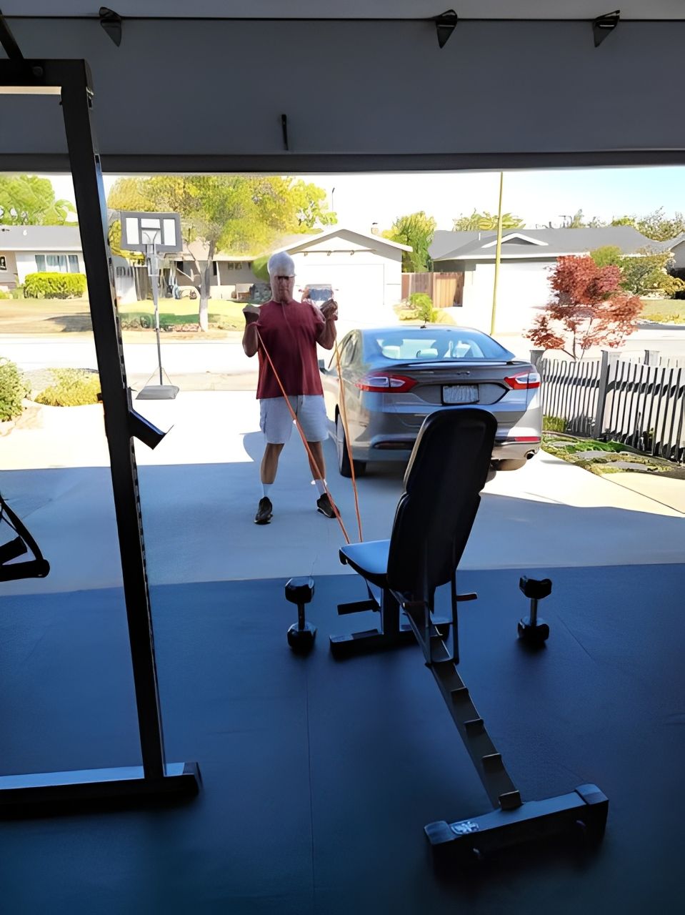 A man is standing in a garage holding a boxing glove.