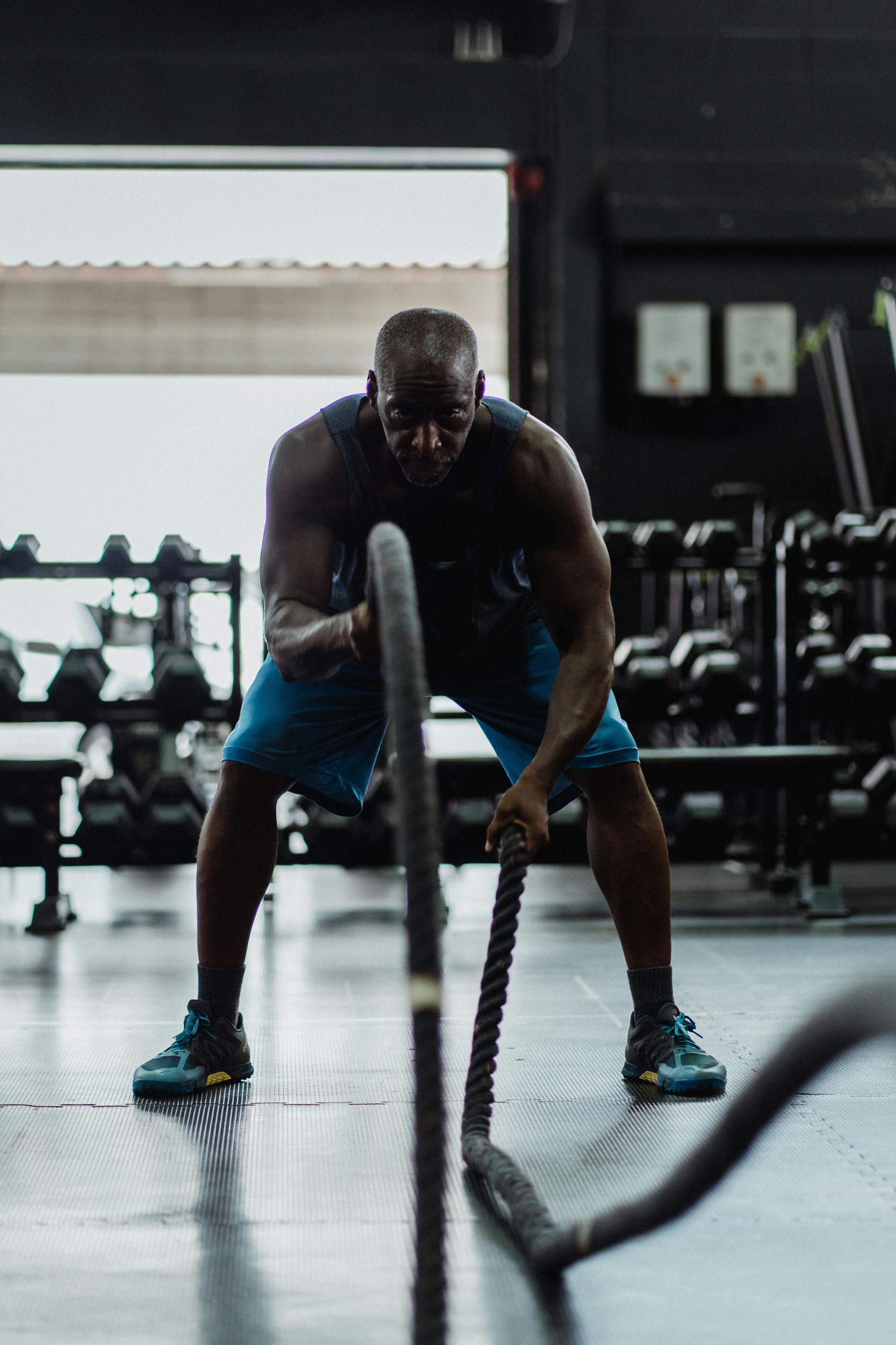 A group of people are doing exercises with dumbbells in a gym.