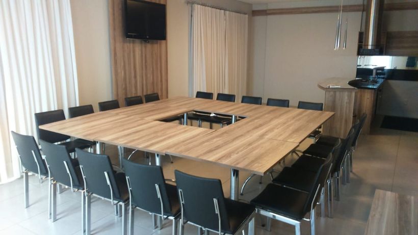 A large wooden table with black chairs in a room.