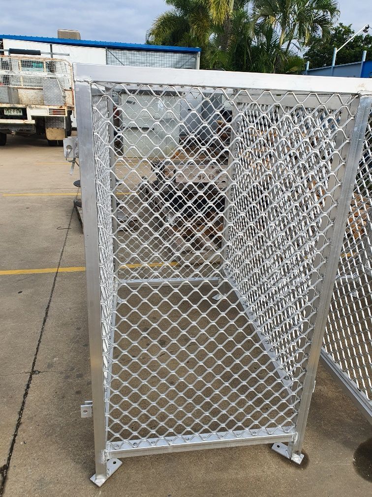 A Metal Fence With Wheels Is Sitting On The Side Of A Road — DMC Electrical & Air Cooling Pty Ltd in Townsville City, QLD