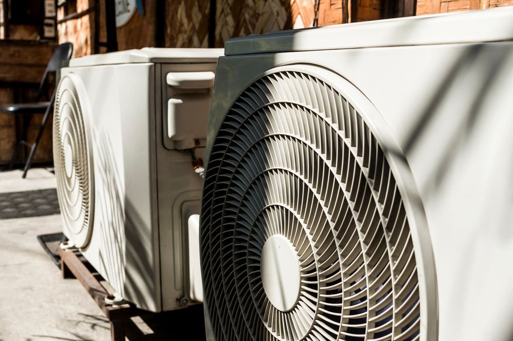 Two Outdoor Air Conditioning Units on a Metal Stand, Facing Forward